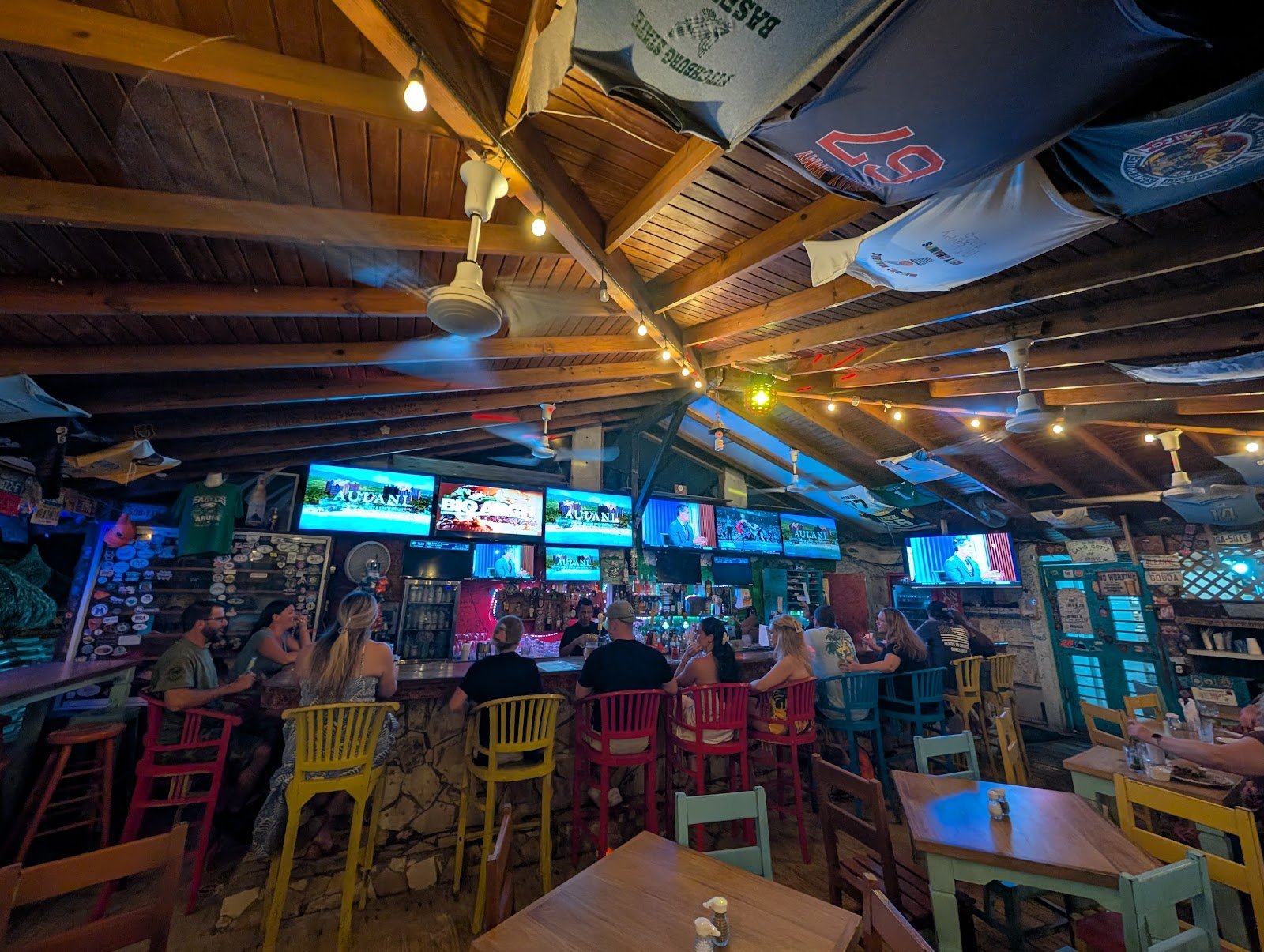 Inside the open-air bar at Carlitos on Palm Beach, with team jerseys and string lights under the wooden roof