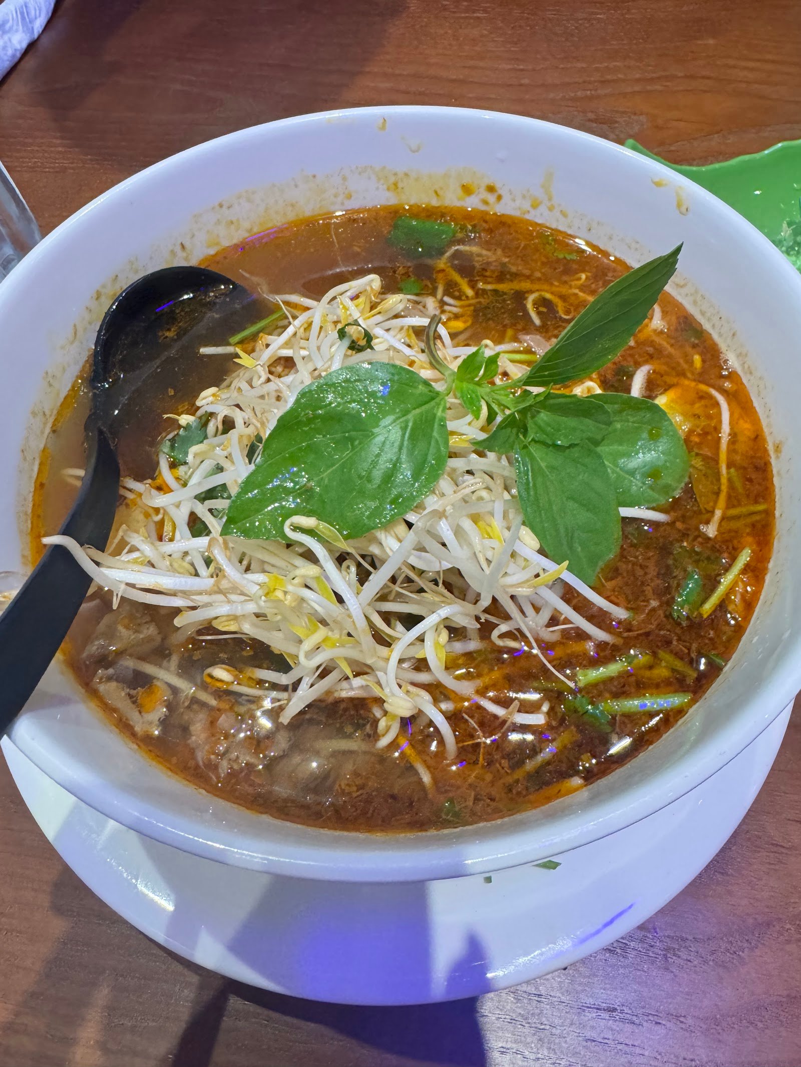 Bun bo hue at Pho Maison Aruba, topped with bean sprouts and fresh basil