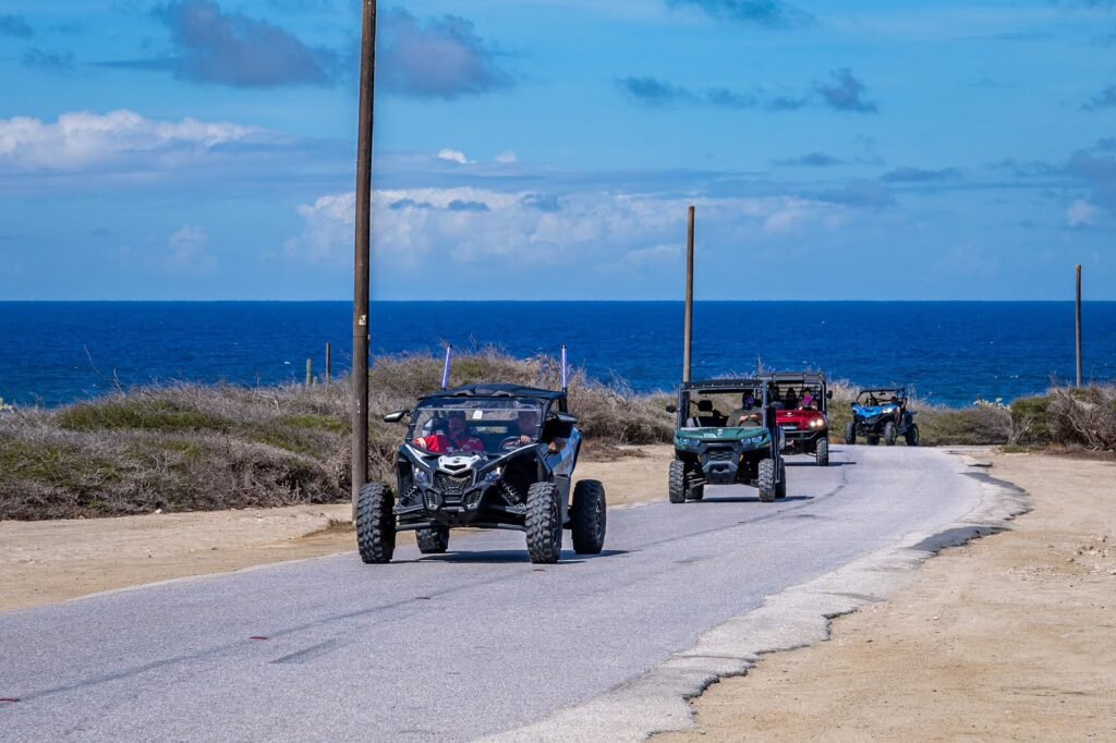 A convoy of UTVs on the coast road in Aruba