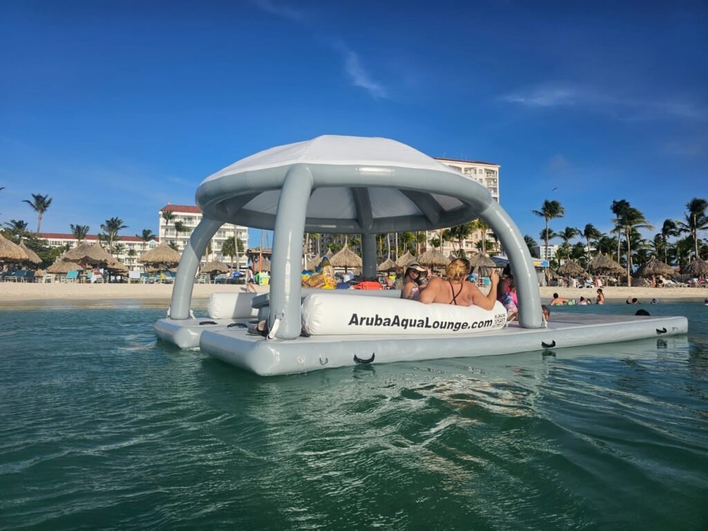 Aruba Aqua Lounge Bonanza Lounge with its white dome canopy off a palapa beach, guests relaxing under the shade
