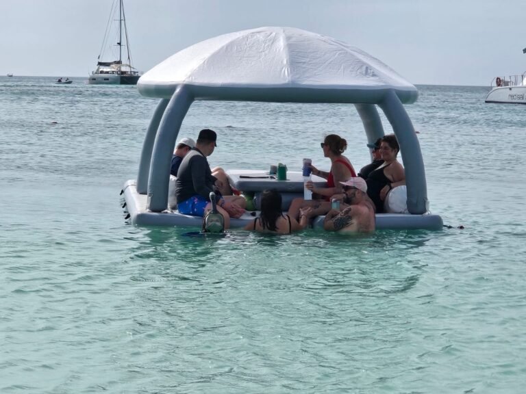 Group sitting and swimming around the Bonanza Lounge in clear shallow water