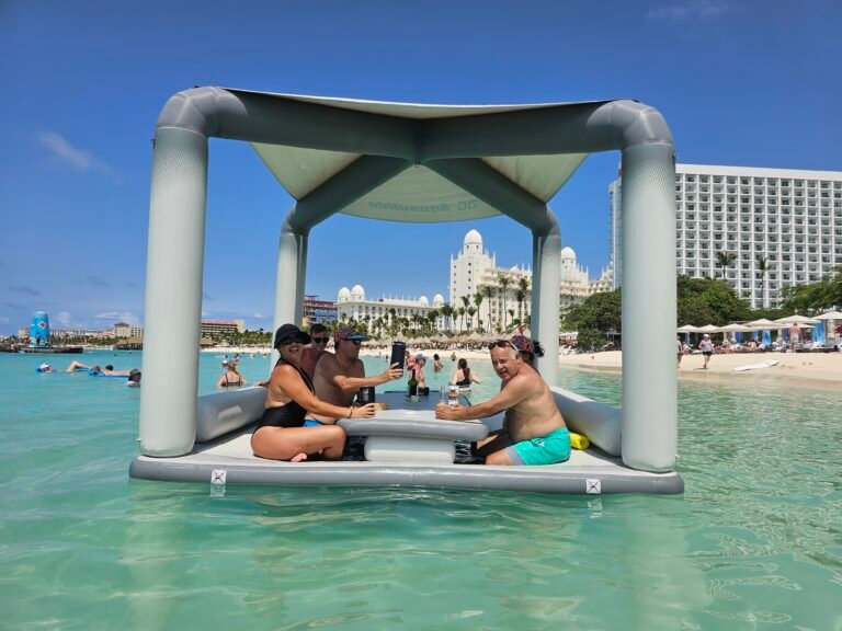 Friends relaxing in the shade of a floating lounge canopy, beach hotels behind them